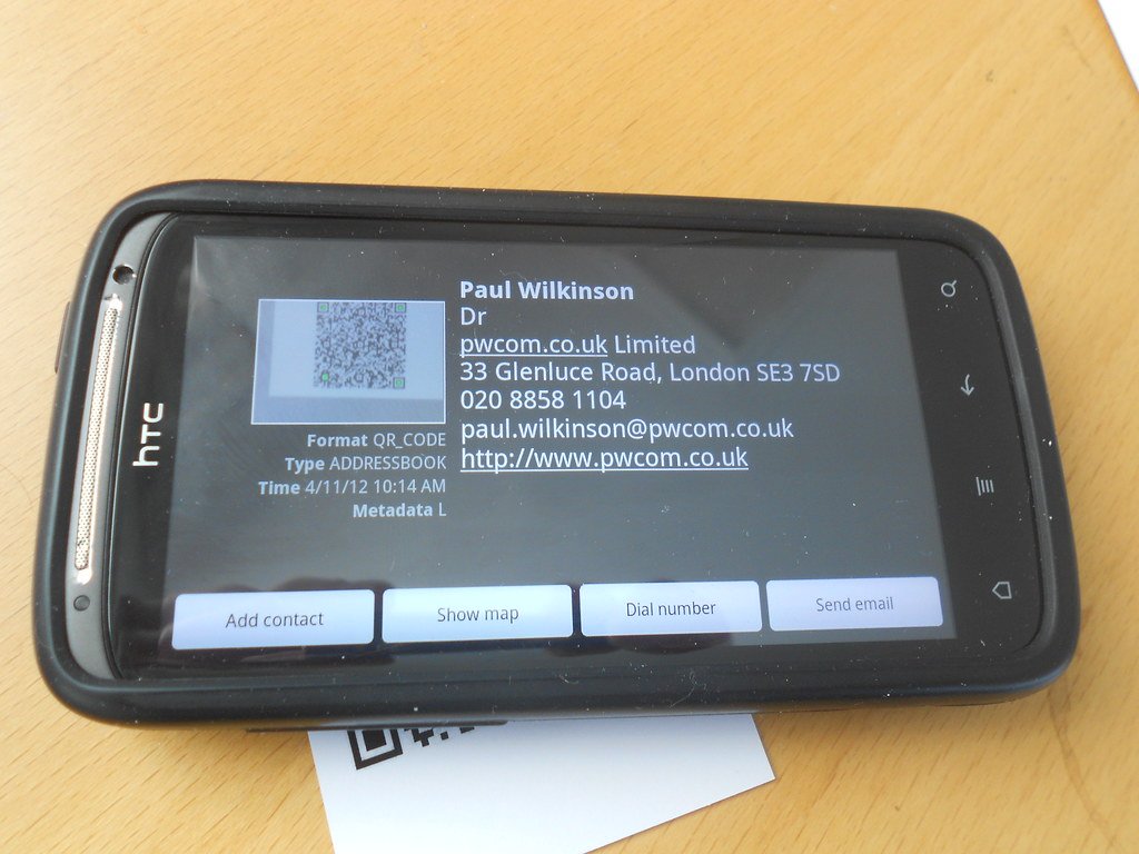 Hand holding phone scanning a QR code — illustration of QR code phishing risk